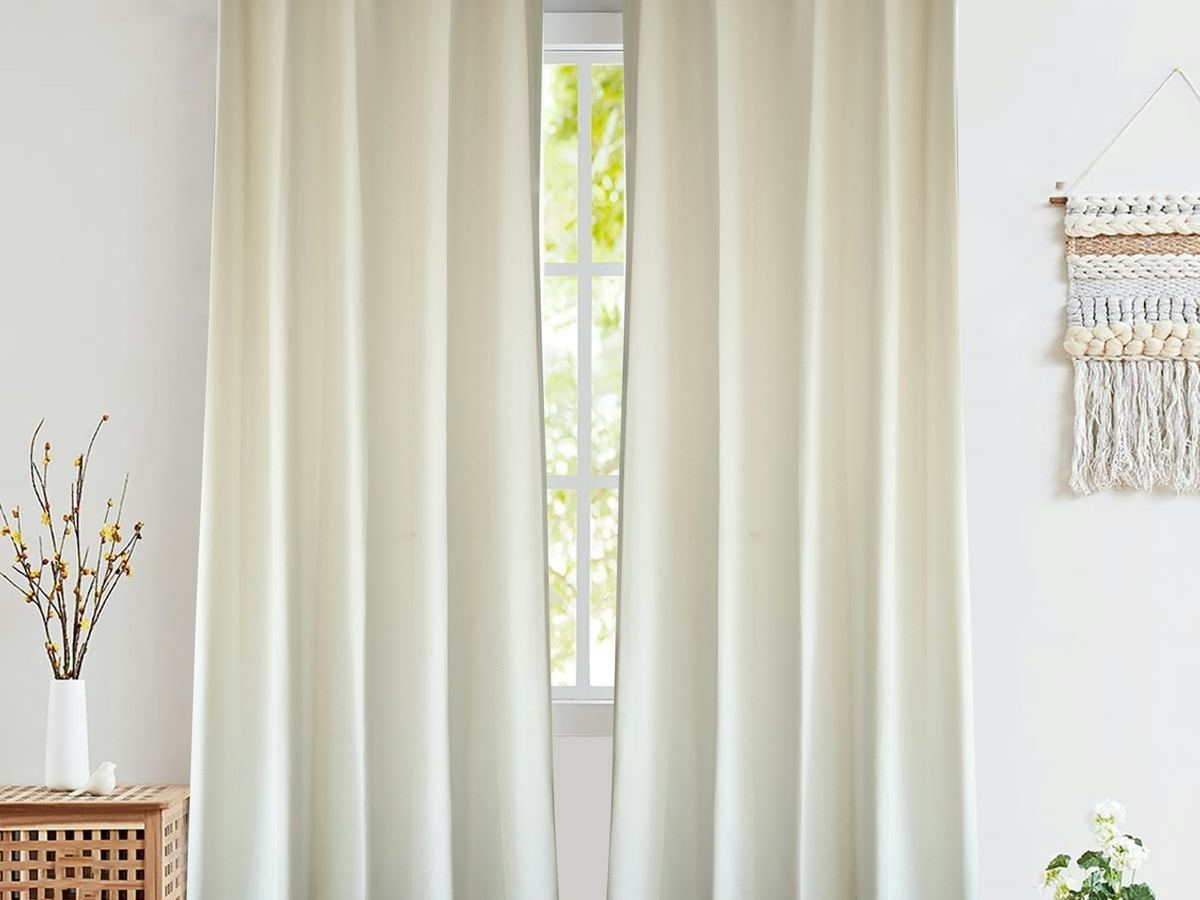 Floor-length cream curtains at a bright window in a modern room