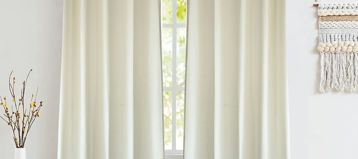 Floor-length cream curtains at a bright window in a modern room